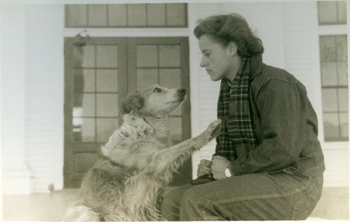 Student and dog in front of a rear entrance of Lee Hall