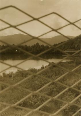 View through the fence from the Studies Building of Lake Eden and the Dining Hall