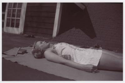 Verna Raattama Schauffler or Dorothy Raattama Bergman sunbathing on the roof of a lodge at the Lake Eden campus